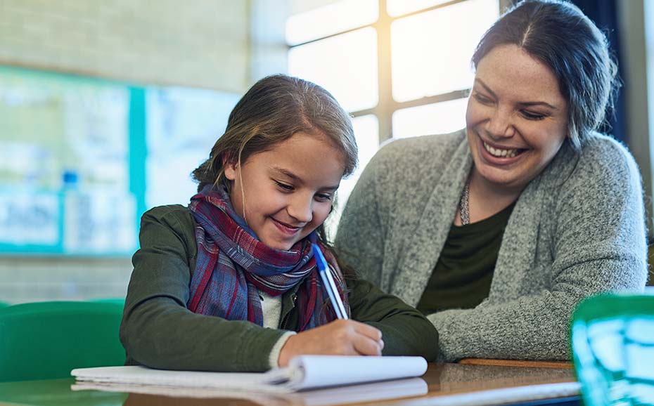 Adult gives a child one-to-one learning support